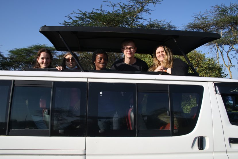 Jørdi, Abelone, Nina, Casper og Irene Elise titter ut av en mini-van på safari. Alle smiler mot kamera. 